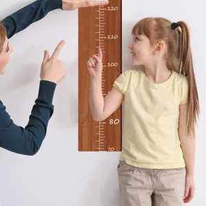 Detalle de la regla de crecimiento de madera para ninos con escala de 70cm a 120cm.