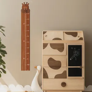 Detalle del medidor de altura de jirafa de madera con escalas claras en la pared.