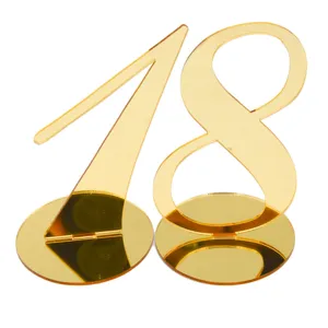 Detail shot of golden acrylic table number 18 with round base for wedding restaurant decor.