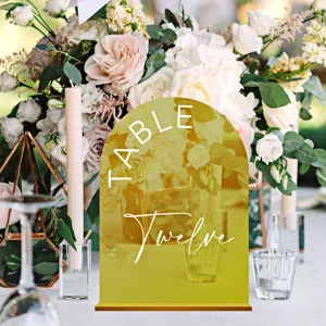Acrylic arch table number sign detail view with golden mirror finish and white wedding typography.