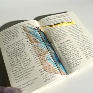 Creative translucent acrylic bookmark with golden tassel, colorful light refracting design.
