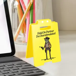 Close-up detail of funny yellow acrylic desktop sign ornament with novelty cowboy frog graphic.