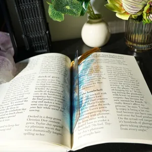 Detailed view of translucent acrylic bookmark with ocean wave design and golden tassel.
