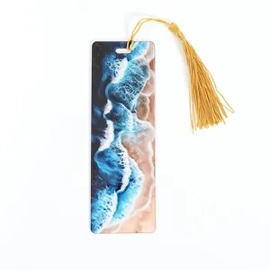 Close-up detail of the creative ocean wave patterned acrylic bookmark with a golden tassel.
