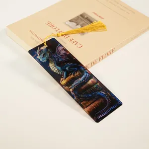 Detailed view of translucent acrylic dragon bookmark with gold tassel, premium reading accessory.
