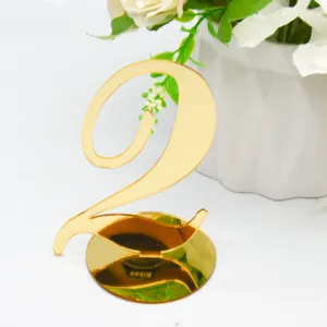Close-up shot of a shiny gold acrylic table number two with a round base for wedding decor.