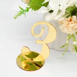 Gold mirror acrylic table number 3 sign detail shot with elegant flower vase decoration.