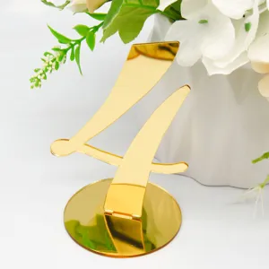 Gold mirrored acrylic table number 4 detail shot, elegant wedding decor element close up.
