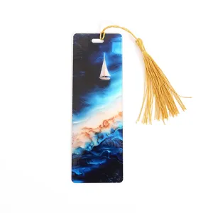 Translucent acrylic bookmark with blue ocean sailboat pattern and elegant golden tassel.