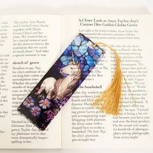 Close-up detail of translucent acrylic bookmark with unicorn art and gold tassel.