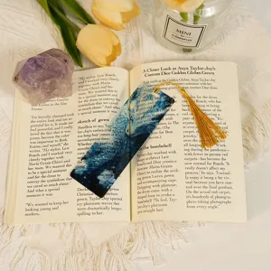 Detail view of translucent dragon pattern acrylic bookmark with tassel for students.