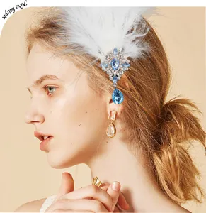 Elegante horquilla de plumas blancas con pedrería azul, perfecta para mujeres a la moda.
