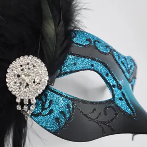 Maschera di carnevale glitterata nera e blu con piume nere e strass per feste.