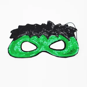 Primer plano de una máscara de lentejuelas verde y negra, ideal para fiestas y disfraces.