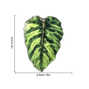 Vue rapprochée détaillée de l'aimant de réfrigérateur en feuille de plante tropicale verte.