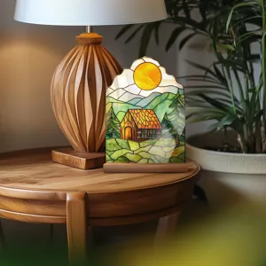 Stained glass style acrylic table ornament featuring a cozy cabin landscape and warm sun design.