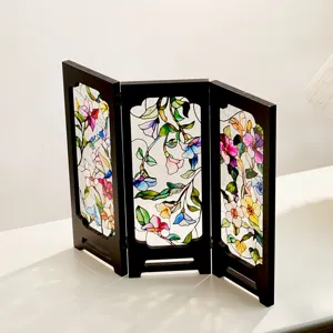 Detailed shot of vintage stained glass three-fold tabletop screen with floral motif.