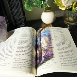 Translucent acrylic bookmark with gold tassel, light refracting decorative art bookmark detail.