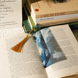 Detailed view of transparent acrylic bookmark featuring a stunning blue dragon and gold tassel.