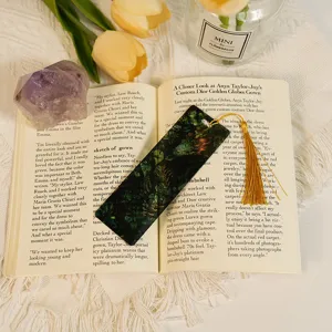 Transparent acrylic dragon bookmark with tassel, detailed view of floral botanical art.