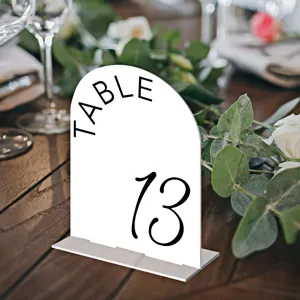 White acrylic arch table number sign detail for wedding decor and table seating arrangement.