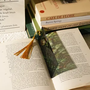 Translucent acrylic bookmark with dragon pattern and tassel detail. Perfect reading accessory.