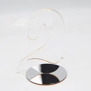 Clear acrylic table number 2 sign with mirror base, elegant wedding and restaurant decor detail.