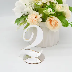 Detailed view of the elegant white and gold acrylic table number 2 for wedding decor.