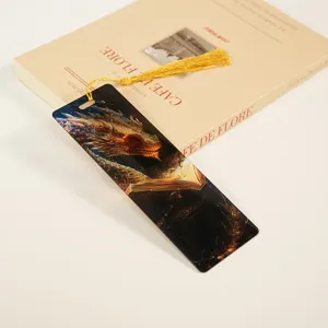 Detail shot of a translucent acrylic bookmark featuring a magical dragon pattern and gold tassel.