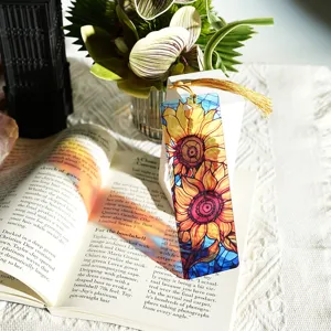 Close-up of translucent acrylic sunflower bookmark with gold tassel, artistic stained glass style.