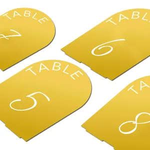 Gold acrylic arched table number cards with white print for wedding reception party decor.