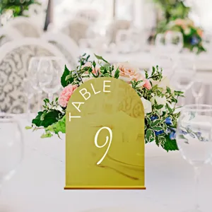 Gold acrylic arched wedding table number sign detail display, elegant party decor stand.
