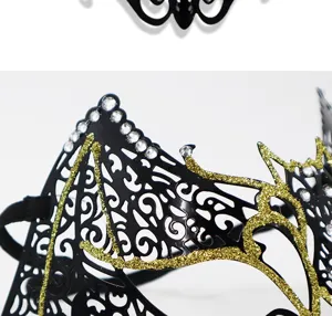 Close-up detail of black and gold masquerade mask with glittering rhinestones and patterns.