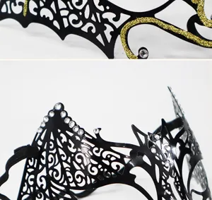 Metal masquerade mask detail view, black cutout design with rhinestones and gold glitter.