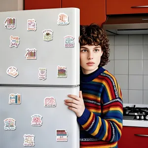 Detail view of cute book-themed decorative fridge magnets displayed on a kitchen refrigerator.
