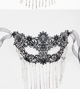 Detailed view of black metal masquerade mask with sparkly rhinestone fringe tassels.
