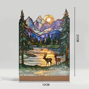 Stained glass style mountain and deer desktop decor lamp with wooden base detail view.