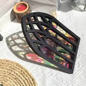 Closeup view of the translucent wooden window decor showing colorful floral details and shadow.