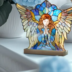 Close-up detail of stained glass style angel acrylic ornament with wooden base home decor.