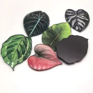 Gros plan détaillé d'aimants de réfrigérateur en acrylique avec des feuilles tropicales.