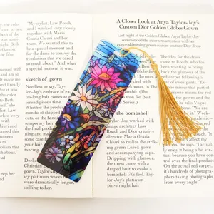 Translucent acrylic bookmark with colorful floral pattern and golden tassel elegant.