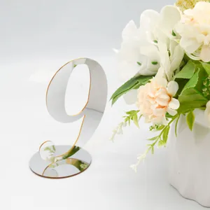 Silver mirrored acrylic table number 9 with round base and wedding floral decor display.
