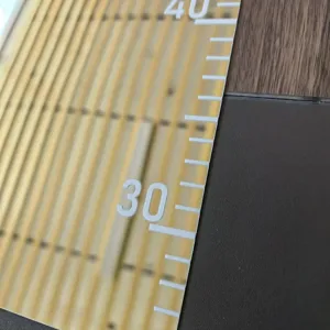 Close-up detail of acrylic mirror height sticker and wall ruler for kids room decor.