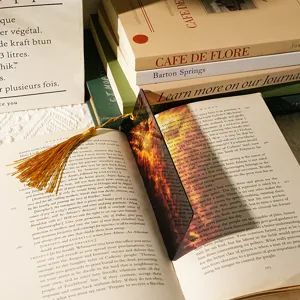Detailed close-up shot of translucent acrylic dragon pattern bookmark with luxury gold tassel.