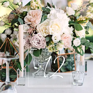 Detailed view of clear acrylic arch table number sign with elegant typography for weddings.