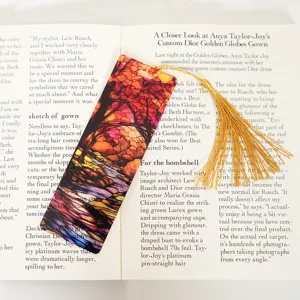 Colorful translucent acrylic bookmark with gold tassel, artistic stained glass design.