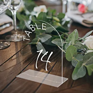 Clear acrylic wedding table number sign with stand, arched design for restaurant events.