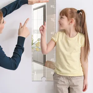Acrylic mirror height chart detail scene showing child measuring height on white wall.