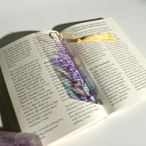 Close-up detail of a colorful translucent acrylic bookmark featuring an elegant gold tassel.