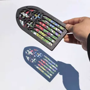 Close-up of gothic arched wooden translucent ornament showing vibrant colorful shadow details.